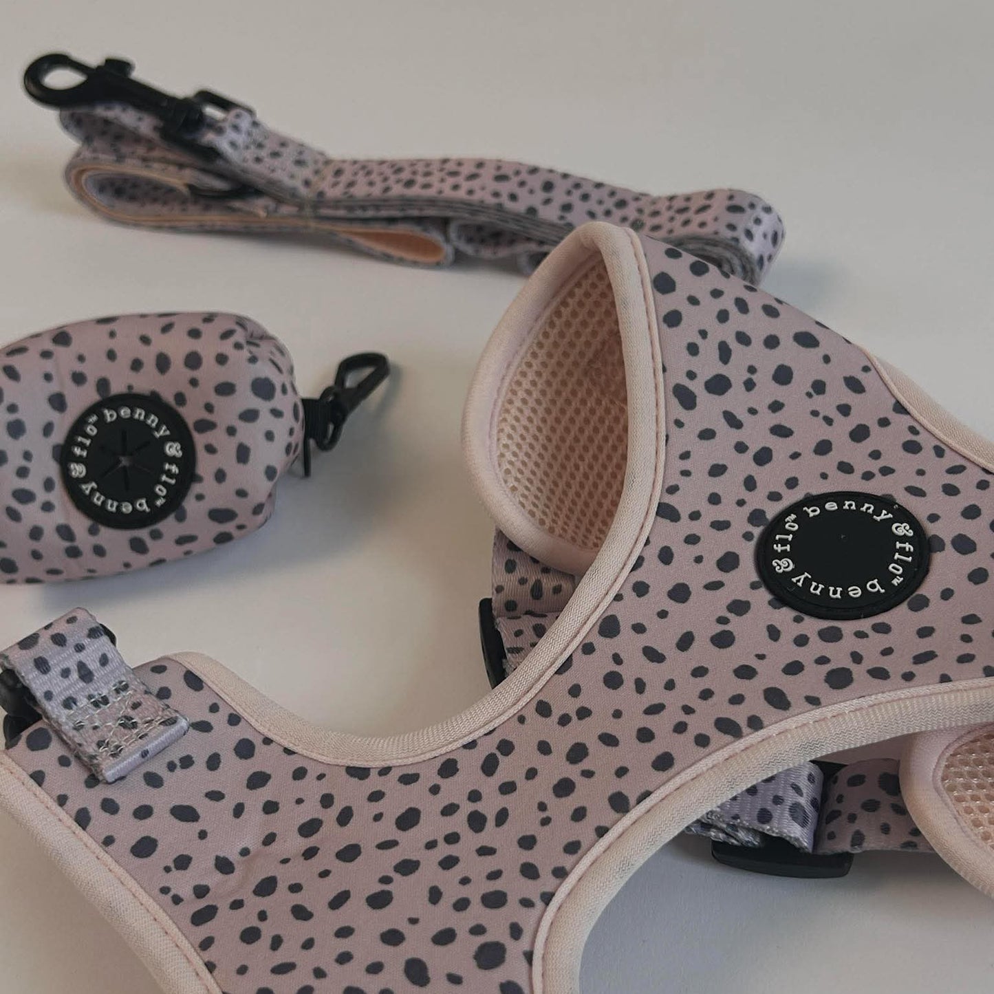 Dog harness with dalmatian pattern and matching leash on a white background