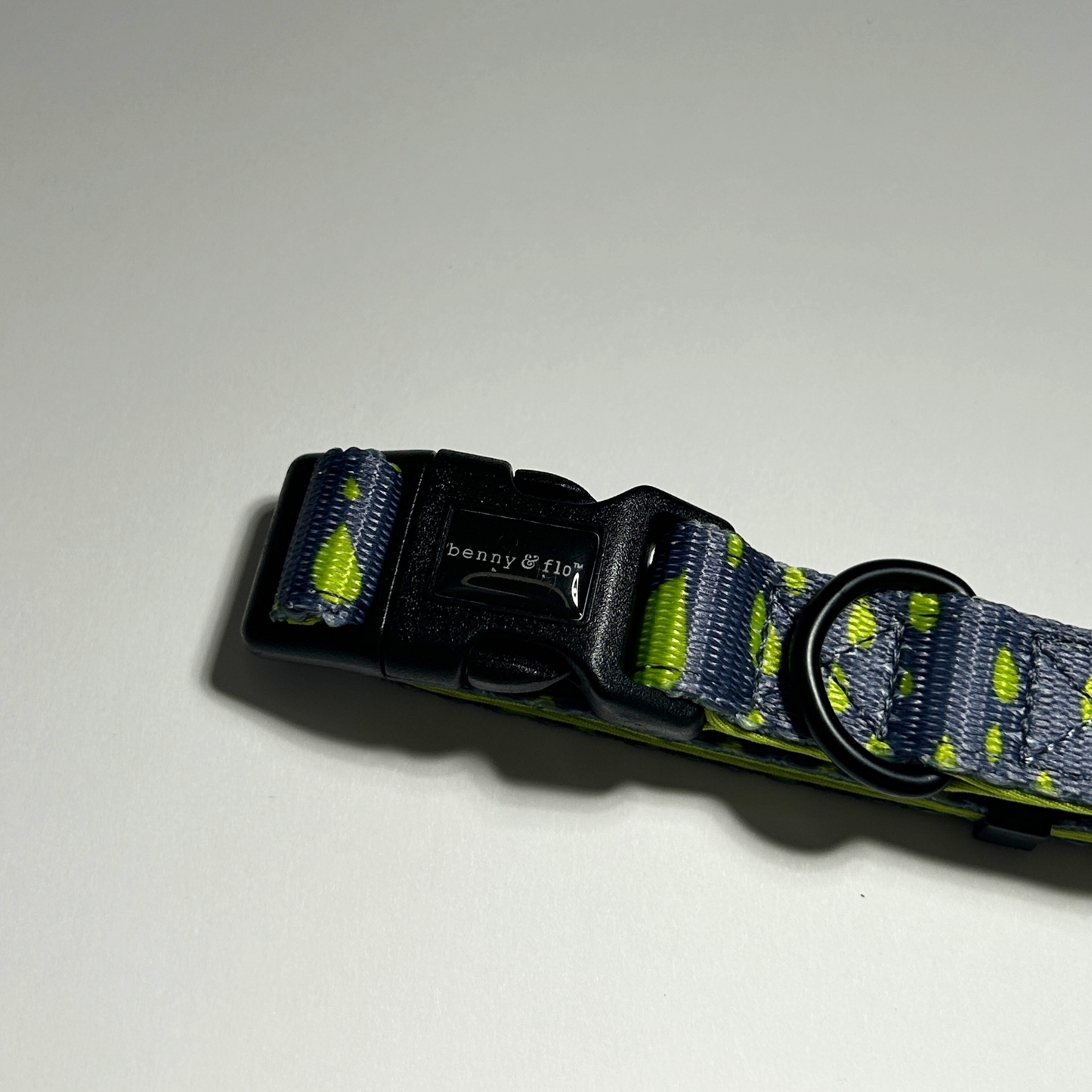 Dog collar with black buckle and green pattern on a white background