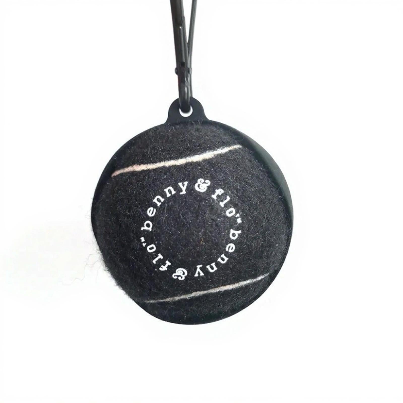 Black tennis ball with 'benny & flo' branding on a white background