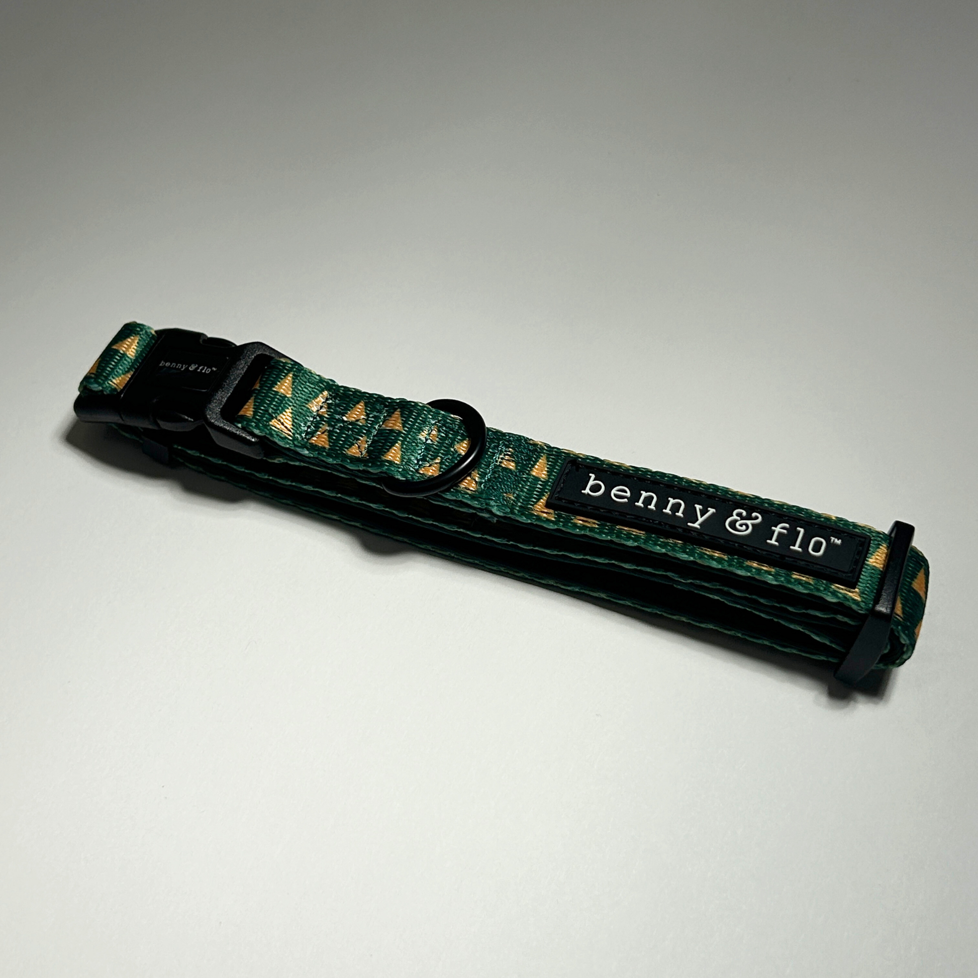 Green dog collar with 'benny & flo' branding on a white background