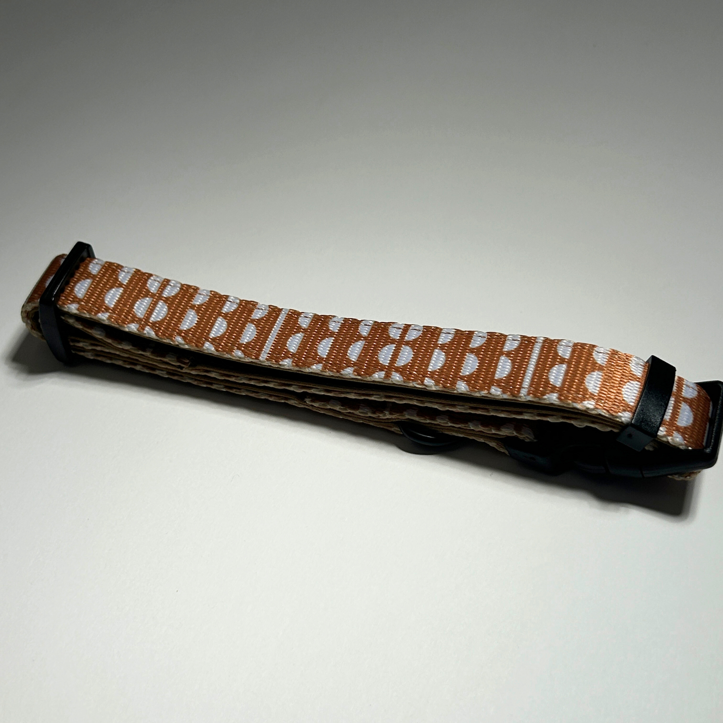 Dog collar with a patterned strap on a white background