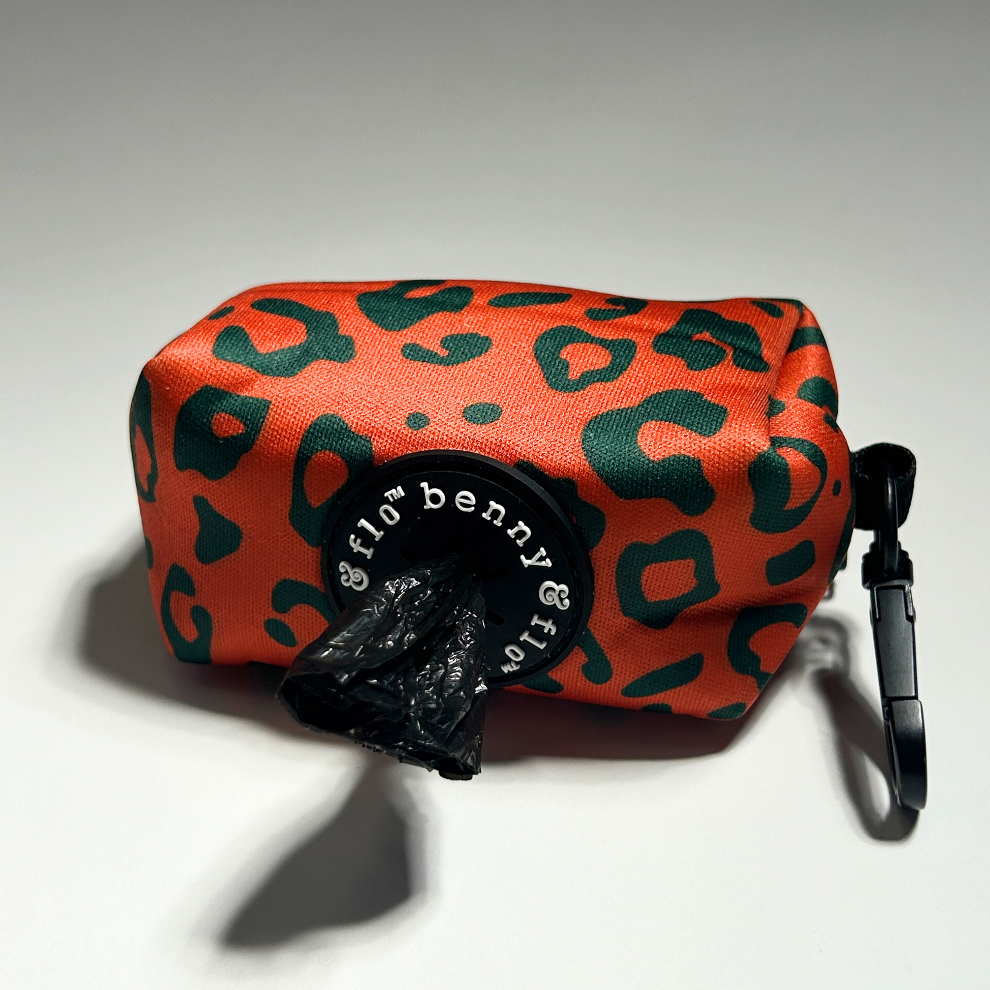 Orange poop bag holder with green leopard print on a white background