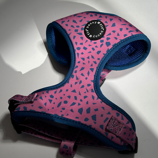 Pink and blue patterned dog harness on a white background