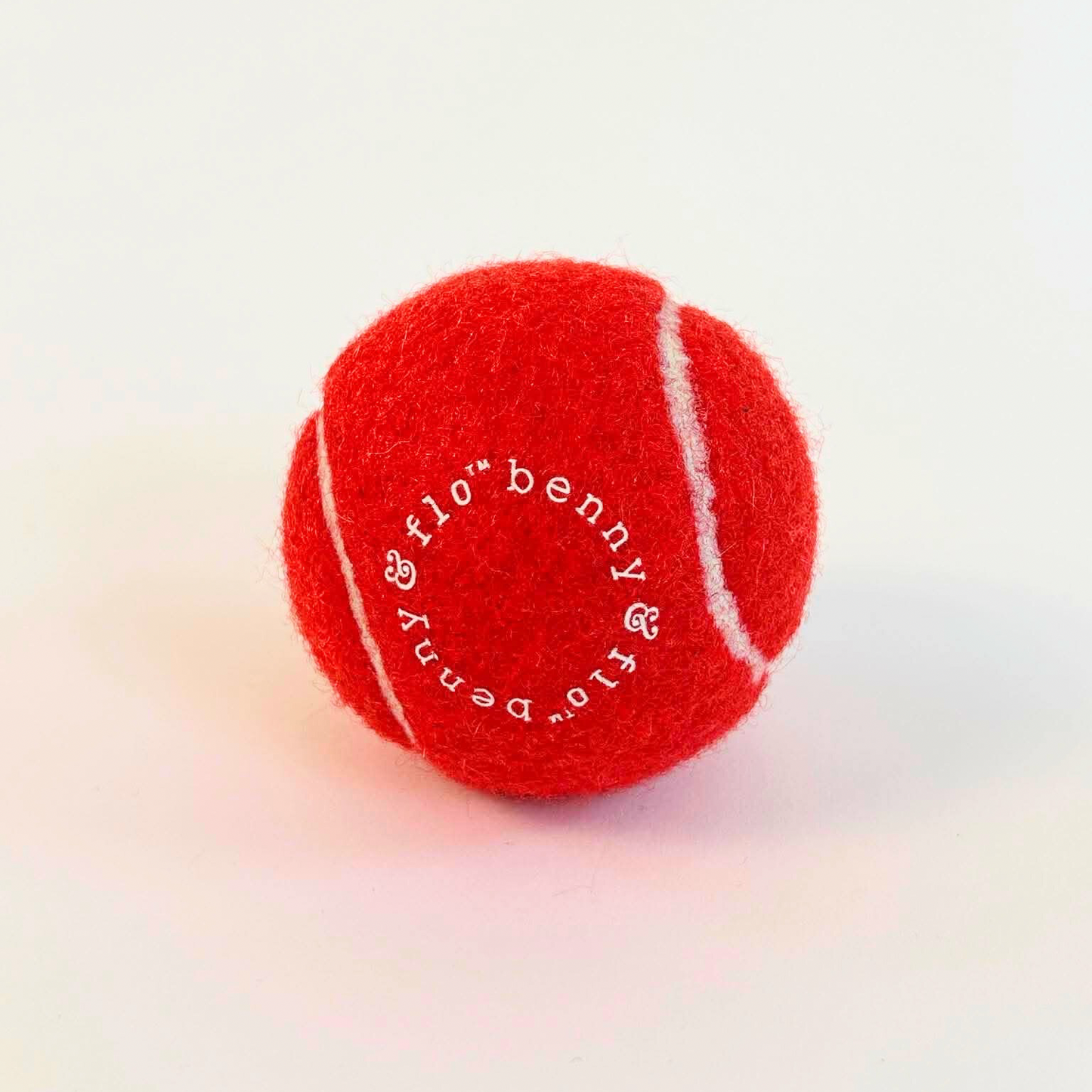 Red tennis ball with white text on a white background