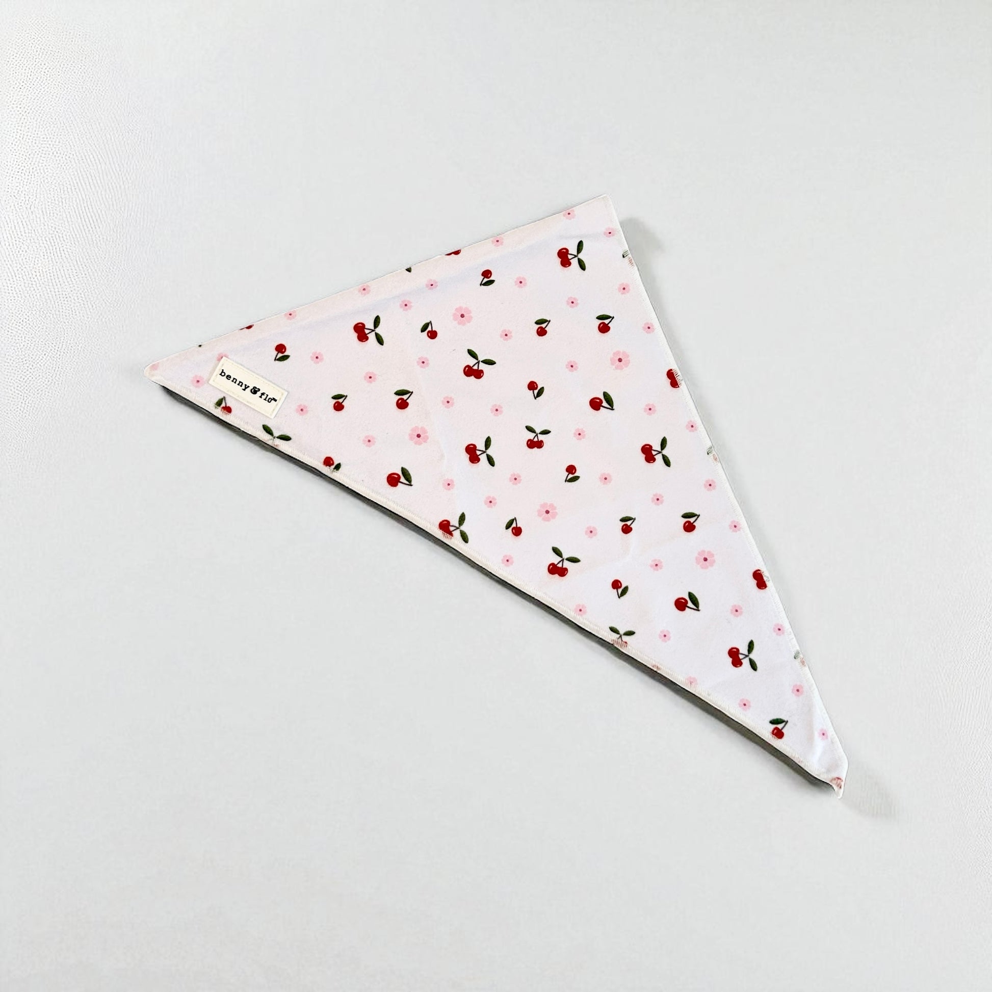Triangular bandana with cherry pattern on a white background